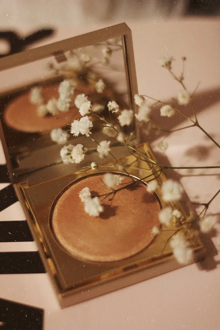 Make-up-Palette und Blüten in warmem, ruhigem Licht