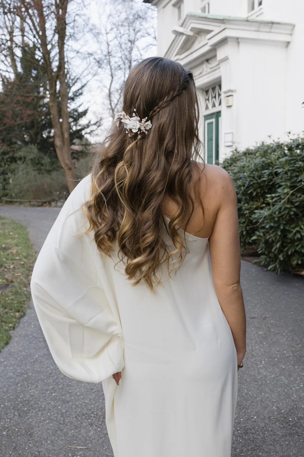 Lange, weich gestylte Brautwellen mit floralem Haarschmuck